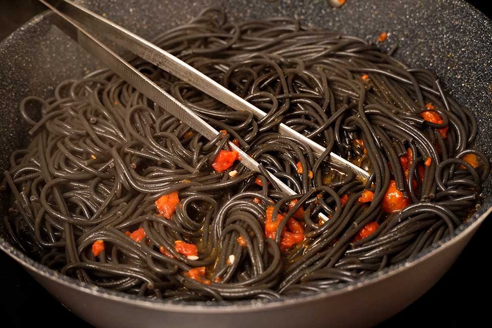 adaugarea spaghetelor in sosul de rosii cu zeama de scoici