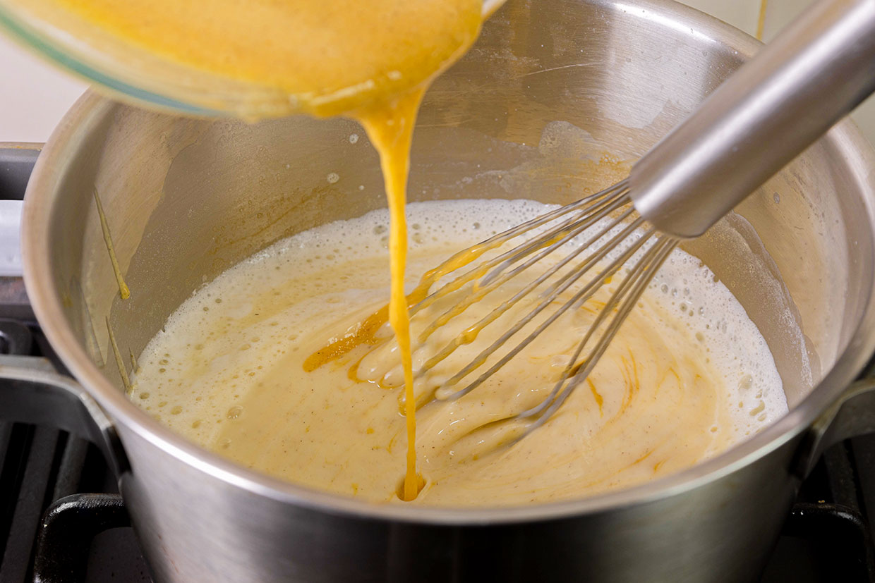 adaugare pasta cu galbenusuri in laptele care fierbe